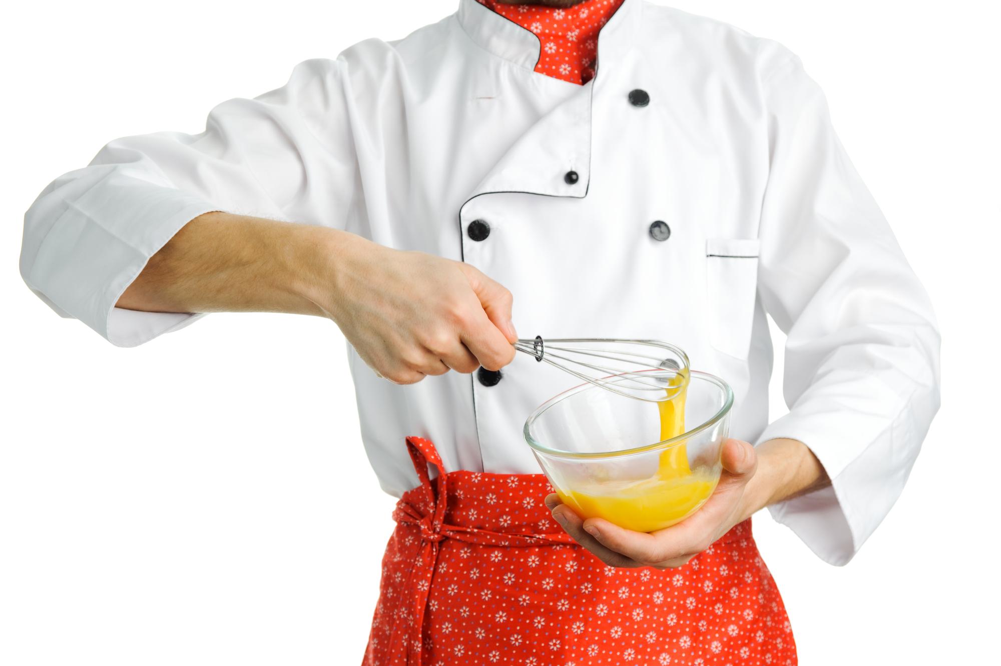 Chef demonstrating plating technique on wooden table